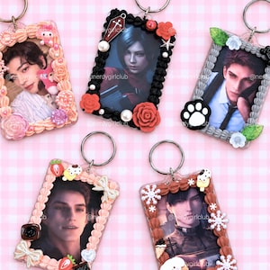 May include: Five rectangular photo card holders with metal keyrings, each decorated with faux whipped cream piping and various charms including flowers, pearls, strawberries, bows, snowflakes, and a paw print, framing different character portraits.