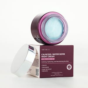 May include: A jar of Calmcool Water Bomb Night Cream by Ruby Vibe Co. The jar is dark purple with a silver lid, and contains a light blue cream. The product box is dark purple with white text, listing ingredients and benefits. The net weight is 1.69 fl oz.