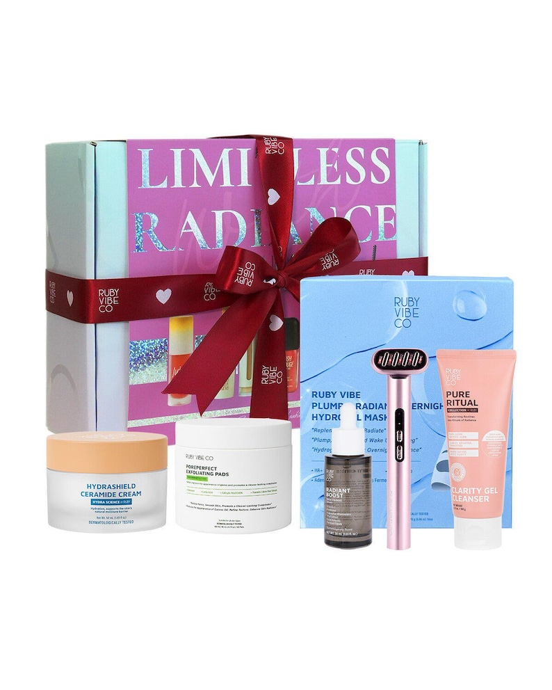May include: A gift set with skincare products, including a cream, pads, serum, a facial massager, and a cleanser. The box is pink and white with the words "LIMITLESS RADIANCE". A red ribbon is tied around the box.