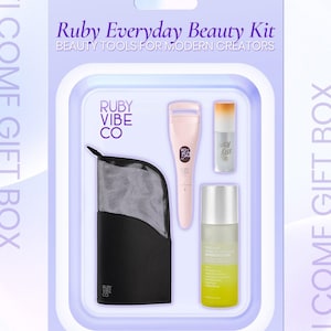May include: A Ruby Everyday Beauty Kit in a light purple package. The kit includes a black mesh bag, a pink eyelash curler, a lip gloss, and a clear bottle with yellow liquid. The text "Ruby Vibe Co" is visible.