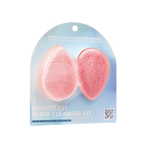 May include: A pink Effortless Glow Cleanser Kit by Ruby Vibe Co. The kit includes a silicone brush and an exfoliating sponge. The packaging is light blue and features the text "Brush & Bloom Collection by Ruby".