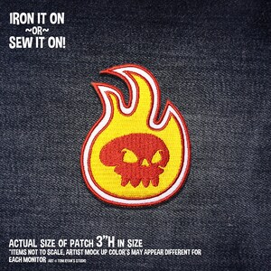 May include: Iron-on or sew-on patch featuring a red skull inside a yellow flame with a white outline. The patch is 3 inches tall. "IRON IT ON ~OR~ SEW IT ON!" and "ACTUAL SIZE OF PATCH 3"H IN SIZE" are written in red text on a dark blue denim background.