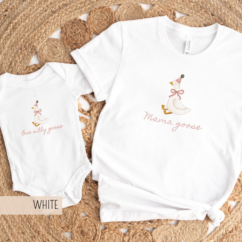 May include: White t-shirt and onesie set. The t-shirt has the words "Mama goose" and the onesie has the words "One silly goose" in a pink script. Both garments feature a cartoon goose wearing a party hat and bow.