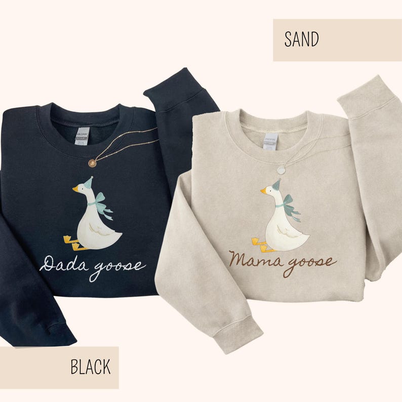 May include: Two sweatshirts, one black and one sand-colored, each featuring a goose graphic. The black sweatshirt has "Dada goose" in script, while the sand-colored one says "Mama goose". Both geese wear party hats and bows.