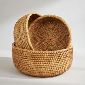 May include: A set of three ceramic canisters with lids. The canisters are white with a blue floral pattern. The largest canister is 8 inches tall, the medium is 7 inches, and the smallest is 6 inches.