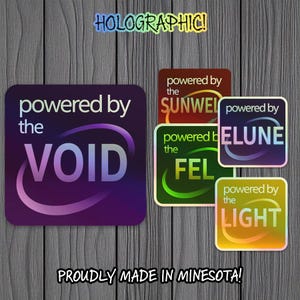 May include: A collection of holographic stickers with various designs and text. The stickers feature phrases like "powered by the VOID," "powered by the SUNWEL," and "powered by the LIGHT." The text "HOLOGRAPHIC!" and "PROUDLY MADE IN MINNESOTA!" are also visible.