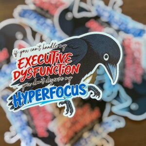 May include: A die-cut sticker featuring a black crow illustration with the text "if you can't handle my EXECUTIVE DYSFUNCTION you don't deserve my HYPERFOCUS" in red and blue lettering, layered over multiple identical stickers in a stack.