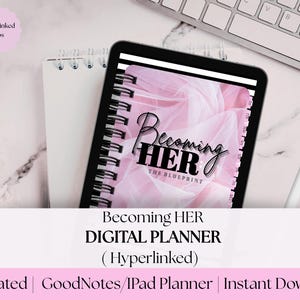 May include: A digital planner on a tablet with the text "Becoming HER" and "The Blueprint". The planner is pink and white with a spiral binding. The image also shows a white notebook, a keyboard, and a stylus.