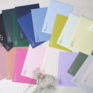 May include: A collection of rectangular paper envelopes in a wide variety of colors including navy, forest green, royal blue, sky blue, lime, pale yellow, dusty rose, fuchsia, candy pink, blush, lavender, sage green, pale gray, and white.