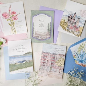 May include: A collection of five rectangular save the date cards featuring watercolor illustrations of flowers, a castle, a coastal landscape, a city building, and a desert plant, accompanied by matching envelopes in pink, purple, and blue.