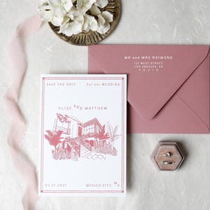 May include: A white save the date card with a pink line drawing of a house, text reading Elise and Matthew, and Mexico City, MX. Accompanied by a dusty pink envelope addressed to Mr and Mrs Raymond, a hexagonal velvet ring box, and a pink ribbon.
