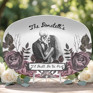 May include: An oval white serving platter featuring a black and white illustration of two skeletons in wedding attire embracing. The text "The Donatelli's" appears above, and a banner with "Til Death Do Us Part" sits below, framed by dark roses.