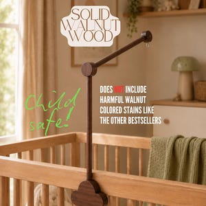 Może przedstawiać: Ramię do karuzeli nad łóżeczko wykonane z ciemnobrązowego litego drewna orzechowego z podstawą w kształcie chmury. Tekst na obrazku brzmi: SOLID WALNUT WOOD, Child safe!, DOES NOT INCLUDE HARMFUL WALNUT COLORED STAINS LIKE THE OTHER BESTSELLERS.