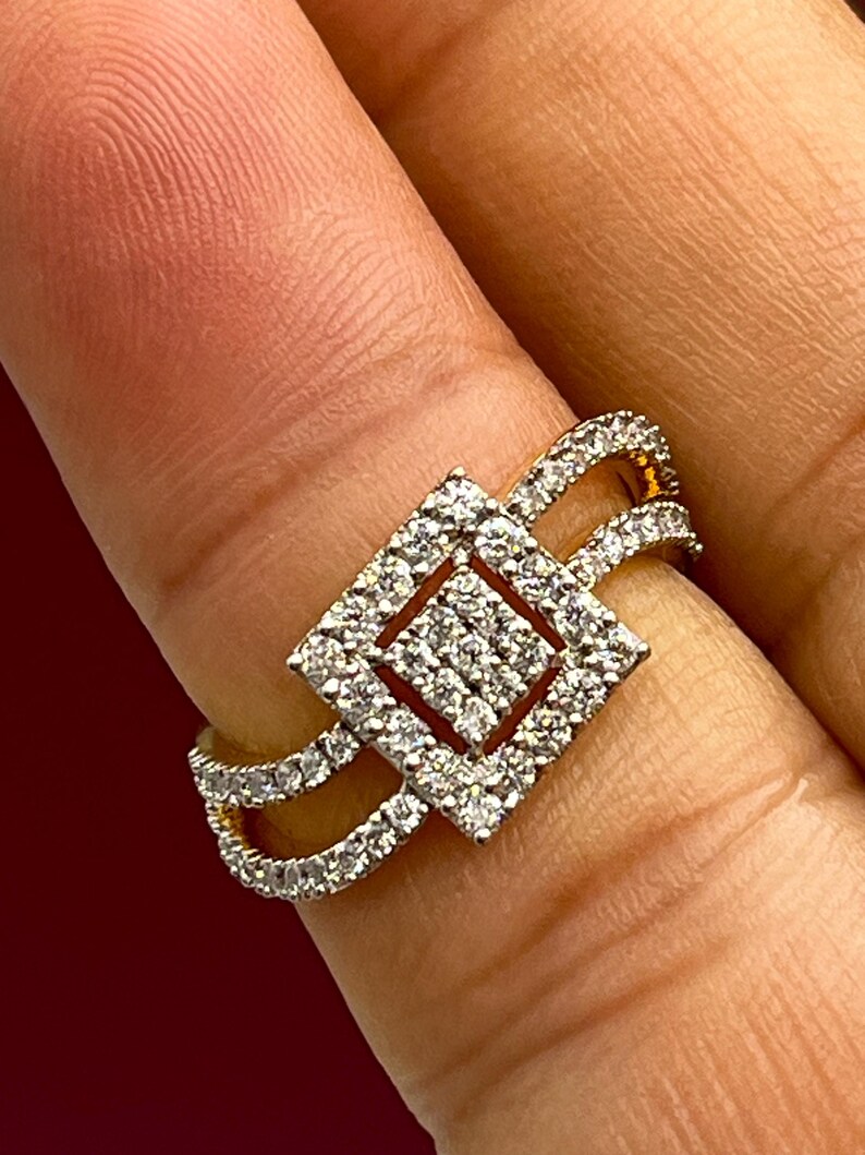 Puede incluir: Un anillo de oro con un dise&ntilde;o cuadrado incrustado de diamantes. El anillo presenta una doble banda y un cuadrado central lleno de diamantes m&aacute;s peque&ntilde;os. Los diamantes brillan sobre el oro, creando un aspecto lujoso.