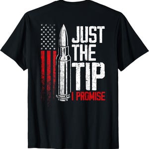 Può includere: T-shirt nero con un design a bandiera americana invecchiata e una grafica a proiettile. Il testo "JUST THE TIP I PROMISE" è in bianco e rosso. Una maglietta grafica con un messaggio umoristico.