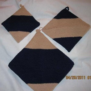 May include: Three crocheted pot holders in a diamond shape with alternating stripes of navy blue and beige.