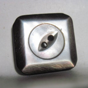 May include: A square, iridescent, mother-of-pearl button with two holes.