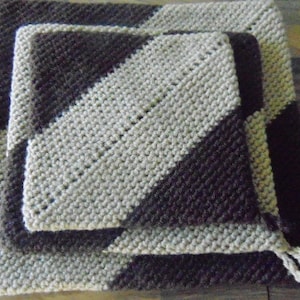 May include: Three crocheted squares, one nested inside the other. The squares are made with a diagonal pattern of brown and white yarn.