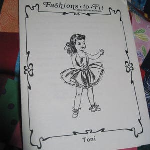 May include: A black and white illustration of a doll wearing a dress and shoes. The illustration is framed with a decorative border and the text "Fashions to Fit Doll Clothes Patterns" is at the top. The text "Toni" is at the bottom of the illustration.