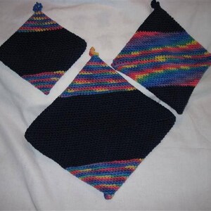 May include: Three crocheted pot holders. Two are black with a diagonal stripe of rainbow colored yarn. One is all rainbow colored yarn.