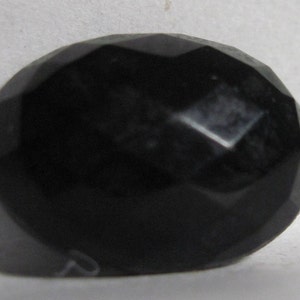 May include: A black oval-shaped gemstone with a faceted cut.