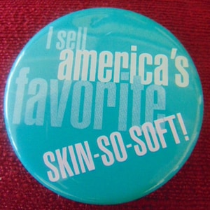 May include: A turquoise blue button with white text that reads "I sell america's favorite SKIN-SO-SOFT!"