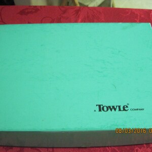 May include: A turquoise blue box with the text "Towle Company" printed in black. The box has a date stamp of "08/03/2016 00:16".