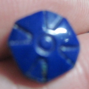 May include: A blue, octagonal, carved gemstone with a starburst design.