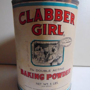 May include: Vintage Clabber Girl baking powder can. The cylindrical can is off-white with red lettering and a blue border. The can features the text "CLABBER GIRL" and "BAKING POWDER". The net weight is 5 lbs (2268 grams).