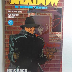 May include: A vintage comic book cover for "The Shadow" by Howard Chaykin. The cover features a figure in a black coat and hat, holding a gun, set against a brick wall. Text includes "He's Back..." and "For Mature Readers."