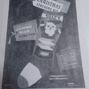 May include: A black and white advertisement for a Bucilla Christmas stocking kit, jumbo size, kit number 7712. The image displays a knitted stocking featuring a Santa Claus graphic, the name SUZY, and text including PERMANENTLY MOTHPROOFED.