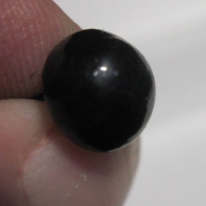 May include: A single, round, black bead.
