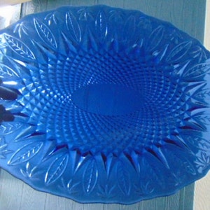 May include: A large, cobalt blue glass serving dish with a diamond pattern and a leaf design around the edge.