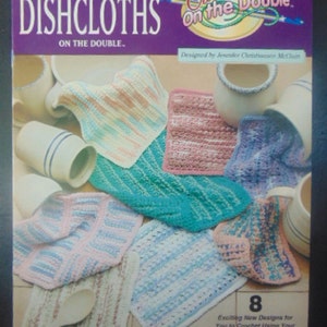 May include: Crochet on the Double: Dishcloths pattern book with 8 new designs for crocheting dishcloths using a double-ended hook and worsted-weight yarn. The cover features a variety of colorful crocheted dishcloths.