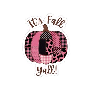 Peut inclure: Un autocollant découpé représentant une citrouille au motif patchwork dans des tons de rose, noir et blanc, incluant des motifs à carreaux, à pois et à taches de vache. Le texte "It's fall yall!" est écrit en brun au-dessus et en dessous.