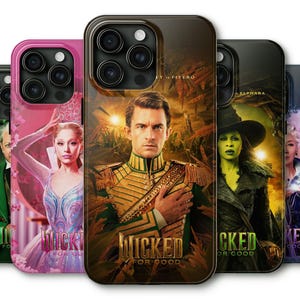 May include: A collection of phone cases featuring characters from the musical "Wicked." The cases display images of actors in costume, with the musical's title and the phrase "For Good" prominently displayed. The cases have a glossy finish.