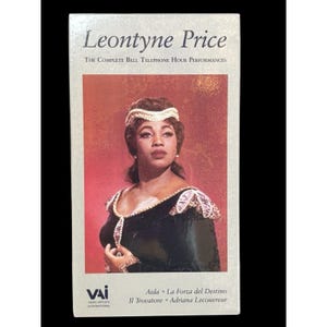 May include: A VHS tape featuring Leontyne Price, with text reading "Leontyne Price The Complete Bell Telephone Hour Performances." The cover displays a portrait of Price in a dark dress with gold trim. The bottom lists opera titles: Aida, La Forza del Destino, Il Trovatore, and Adriana Lecouvreur.