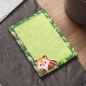 Peut inclure: Bloc-notes rectangulaire avec un fond vert clair et une bordure sur le thème du bambou. Un panda roux de dessin animé est représenté dans le coin inférieur droit. Le bloc-notes est sur un bureau en bois à côté d'un ordinateur portable et d'une plante en pot.
