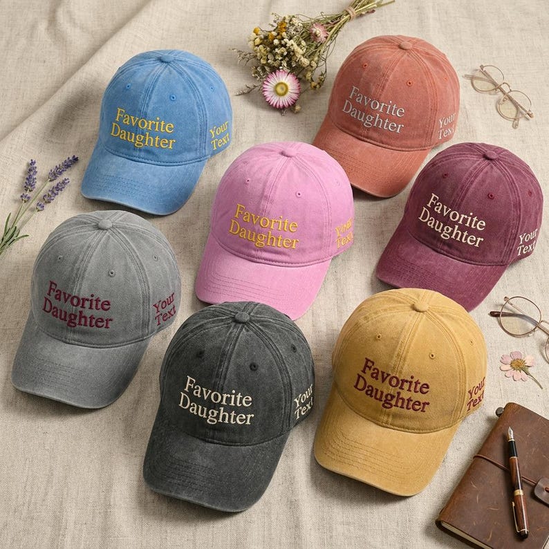 May include: A collection of baseball caps in various colors, including blue, pink, gray, black, red, and yellow. Each cap features the embroidered text "Favorite Daughter" on the front and "Your Text" on the side.