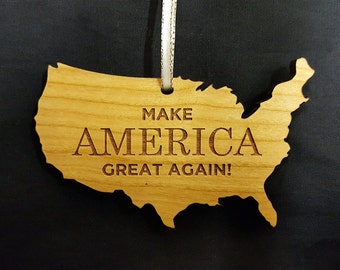 May include: Wooden ornament shaped like the United States of America with the text "MAKE AMERICA GREAT AGAIN!" engraved on it.