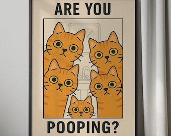 Op de afbeelding: Een ingelijste poster met een cartoon illustratie van vijf oranje katten met grote gele ogen. De tekst "ARE YOU" staat bovenaan en "POOPING?" onderaan. De poster wordt aan een muur getoond.