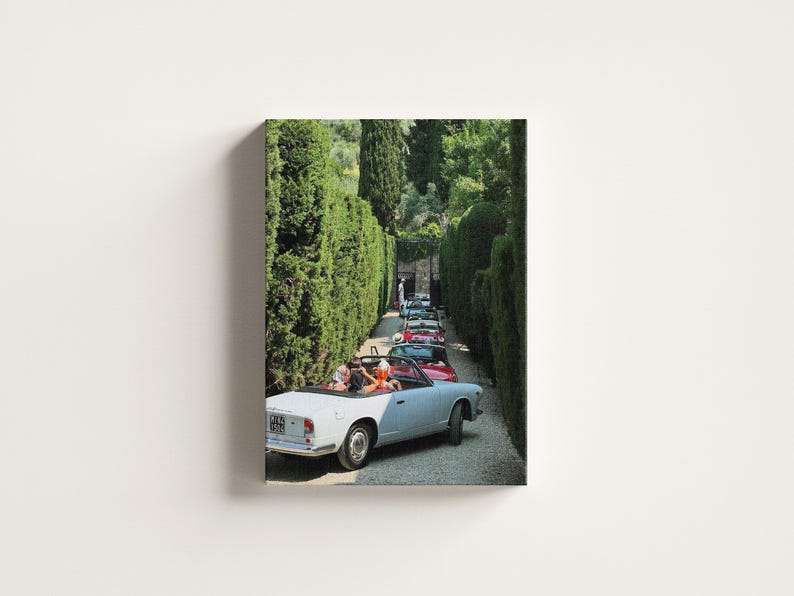 May include: A print depicting a line of classic convertible cars driving along a tree-lined path. The lead car is light blue, with passengers visible. The scene is bathed in sunlight, creating a nostalgic atmosphere. The image evokes a sense of vintage travel.
