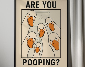 Op de afbeelding: Een ingelijste poster met een cartoonillustratie van verschillende witte ganzen met oranje snavels en poten. De ganzen staan bij elkaar en kijken naar de kijker. De tekst "ARE YOU POOPING?" staat in het zwart bovenaan en onderaan.