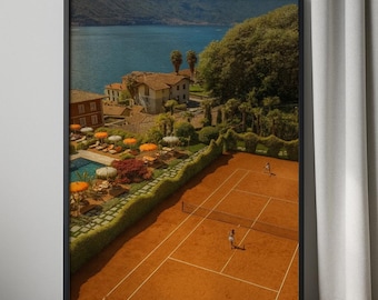 May include: Framed print showing a tennis court with players, set against a backdrop of a lake and buildings. The court is reddish-brown, with a net and white lines. The background includes a lake, trees, and buildings with orange parasols.