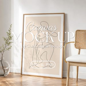 May include: A vertical rectangular framed print featuring a black line art illustration of a person wearing a wide-brimmed hat on a beige background. The text "Canvas MOCKUP by CozyCanvasMockups" and "JPG & PSD" is overlaid on the artwork.