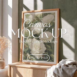 May include: A vertical rectangular wooden frame containing a print of white roses with green foliage. The text "Canvas MOCKUP by CozyCanvasMockups" and "JPG & PSD" is overlaid on the image in white, elegant, and bold sans-serif typography.