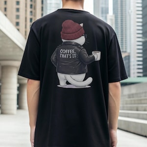 Puede incluir: Camiseta negra con un diseño de gato de dibujos animados. El gato lleva un gorro granate, gafas de sol y una chaqueta de cuero negra, sosteniendo una taza de café. El texto en la chaqueta dice "COFFEE. THAT'S IT". La camiseta es de estilo casual.
