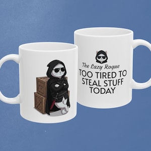 May include: Two white ceramic mugs featuring a cartoon cat dressed as a rogue in a black hooded cloak and sunglasses, leaning against wooden crates. One mug displays the text: The Lazy Rogue TOO TIRED TO STEAL STUFF TODAY.