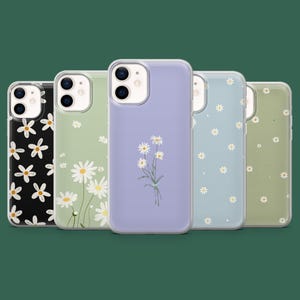 Puede incluir: Cinco fundas transparentes para teléfono con diseños de margaritas. Las fundas presentan fondos en negro, verde claro, lavanda, azul claro y verde oliva. Los diseños de margaritas varían, desde patrones dispersos hasta un ramo.