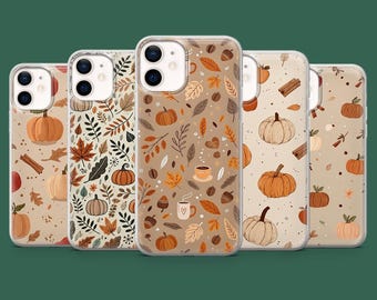 May include: A collection of phone cases with autumn-themed designs. Each case features a different pattern, including pumpkins, leaves, coffee cups, and cinnamon sticks, in shades of orange, brown, and beige. The cases are made of a clear material.